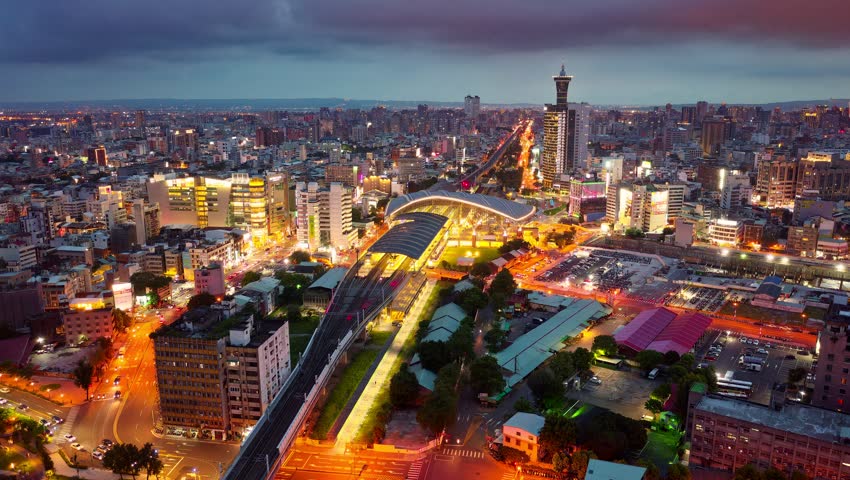 Aerial hyperlapse footage of Taichung, a vibrant metropolis in central Taiwan, with railway tracks extending from the new train station, busy traffic on the streets and city lights dazzling at night