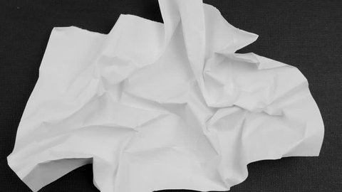 Crumpled sheet on the black background. Stop motion animation.