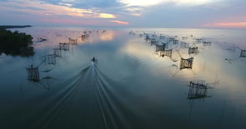4k aerial movie of Thai fisherman Catching Fish with Large fishing net in the Morning at Ban Pak Pra -Talay Noi Lake, Phatthalung, Thailand