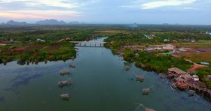 4k aerial movie of Thai fisherman Catching Fish with Large fishing net in the Morning at Ban Pak Pra -Talay Noi Lake, Phatthalung, Thailand