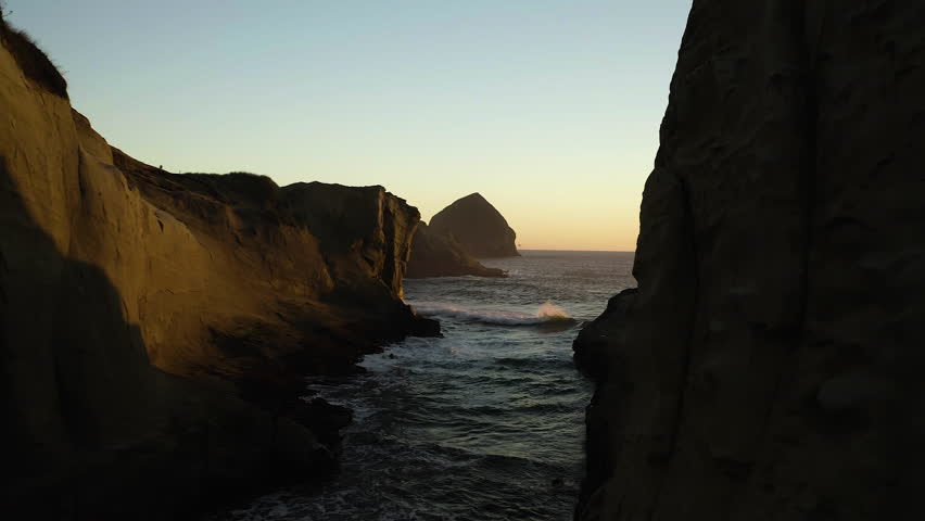 Sandstone cliff valley cove at Cape Kiwanda with Haystack rock at sunset. Oregon Coast. Royalty-Free Stock Footage #3499132099