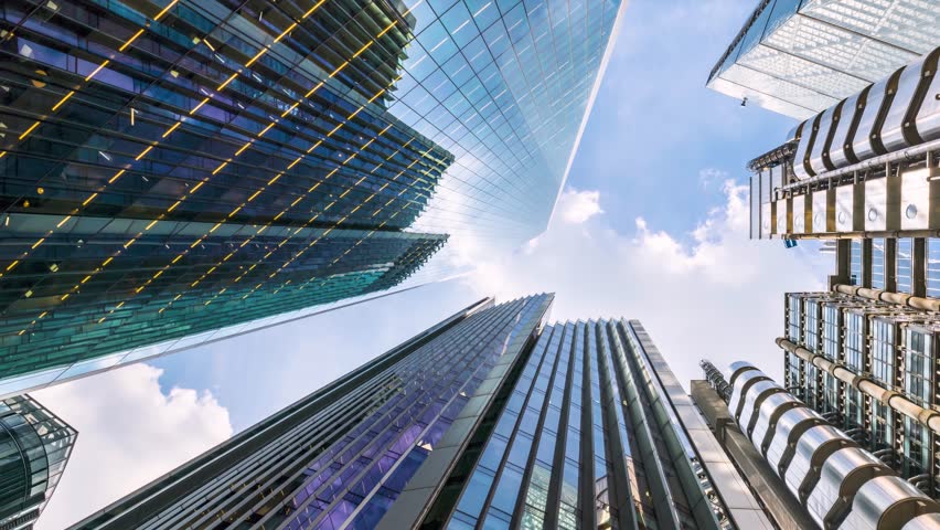 Time lapse view of looking directly up at the skyline of the financial district in central London with clouds passing by, modern architecture as a background
