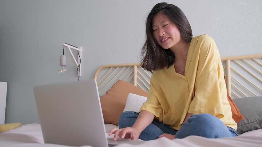 Young Asian woman on video call taking online classes. Chinese teen girl video call. 4k resolution video. E-learning concept.
