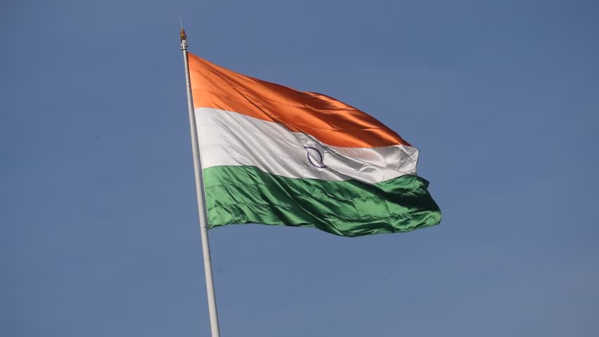 India flag flying high at Connaught Place with pride in blue sky, India flag fluttering, Indian Flag on Independence Day and Republic Day of India, tilt up shot, Waving Indian flag, Har Ghar Tiranga