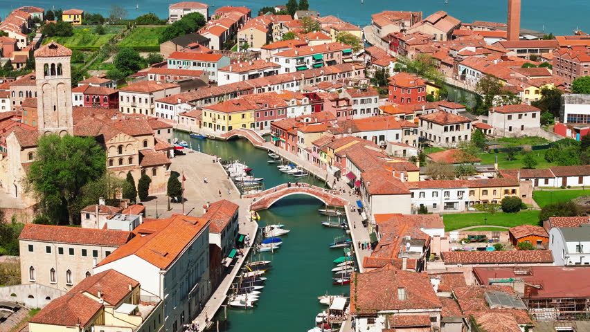 Boats on the canal surrounding Ponte de Mezo bridge in Murano Island, Venice, Italy