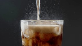 A glass with ice being filled with carbonated soft drink, you can see the fresh bubbles of the beverage. Brown Soda Derives From The can pouring to a glass with ice cube. footage b roll 4k. - Powered by Shutterstock - Get 15% off with code: PIKWIZARD15