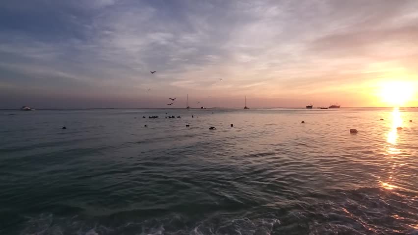 Fiery hues of Los Roques sunset paint sky in a breathtaking display of orange, pink, and purple.
