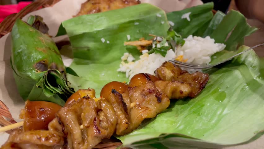 Nasi angkringan or nasi kucing traditional food from central java Indonesia. Nasi kucing with egg satay and chicken skin