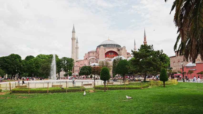Scenic view of the Hagia Sophia with a green park and fountain in the foreground
