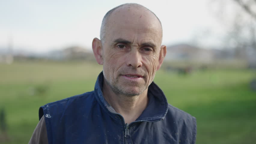 A gardener smiles at the camera in a portrait