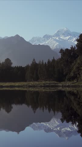 Scenic view of Lake Matheson with amazing view of snowcapped mountains. Fox Glacier town, New Zealand