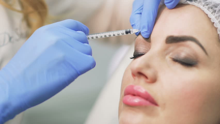 Beautician makes botox injection in the forehead Royalty-Free Stock Footage #34996270