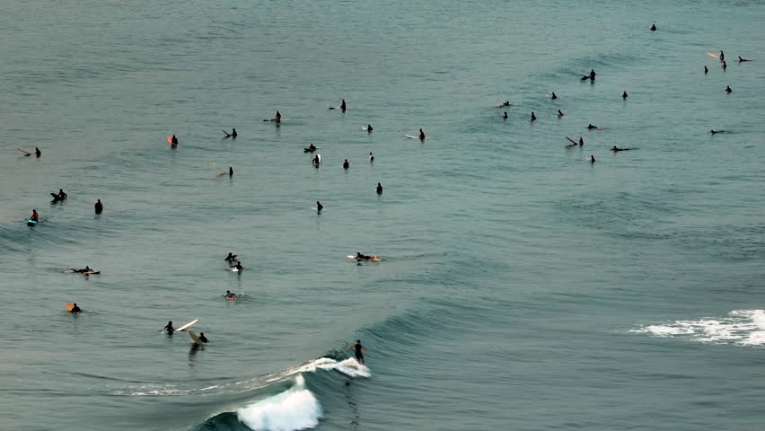 Surfers rides big wave in beautiful calm sunrise on the sea Taiwan.