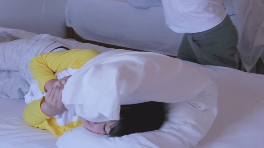 funny pillow fight in in bedroom, happy children, two healthy boys 9-10 years old playfully beat each other with pillows, play together on bed, happy childhood, active games funky siblings at home