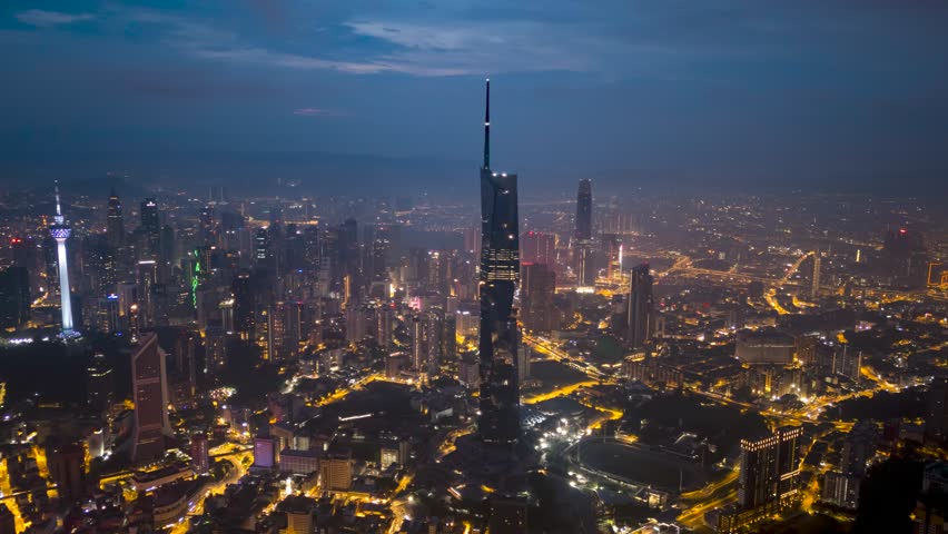 Aerial view time lapse 4k video of Kuala Lumpur city center view at sunrise dawn overlooking the city skyline in Federal Territory, Malaysia during low clouds sunrise. Zoom in