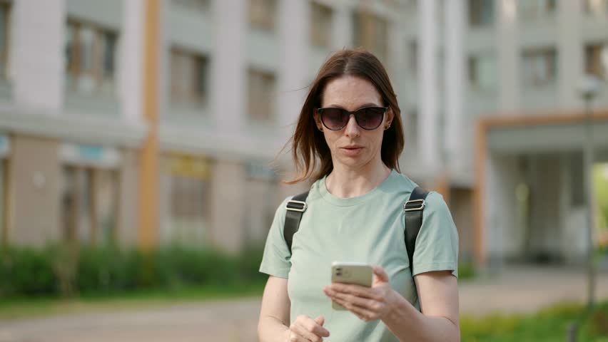 The smartphone has become an integral part of urban life for a beautiful middle-aged woman who does not miss the opportunity to be always in touch.