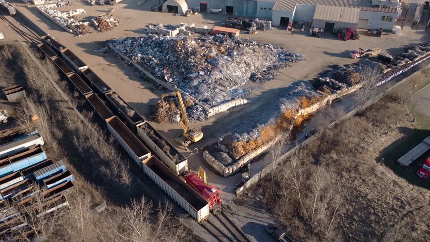 Industrial scrapyard in hamilton, ontario, with excavator and train, aerial view