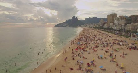 Low aerial shot of Ipanema Beach Rio de Janeiro Brazil with sunset and mountains in background