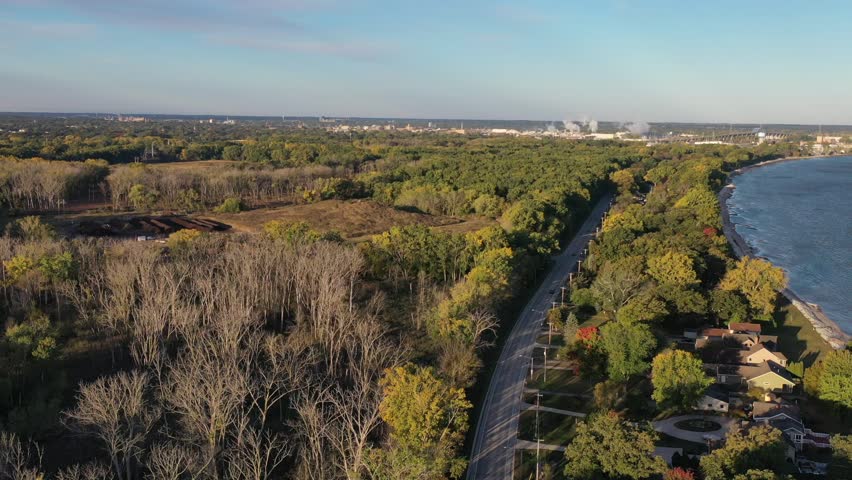 Aerial drone view of Green Bay Wisconsin nature preserve The Wildlife Sanctuary across the road from houses along East Shore Drive; east to west