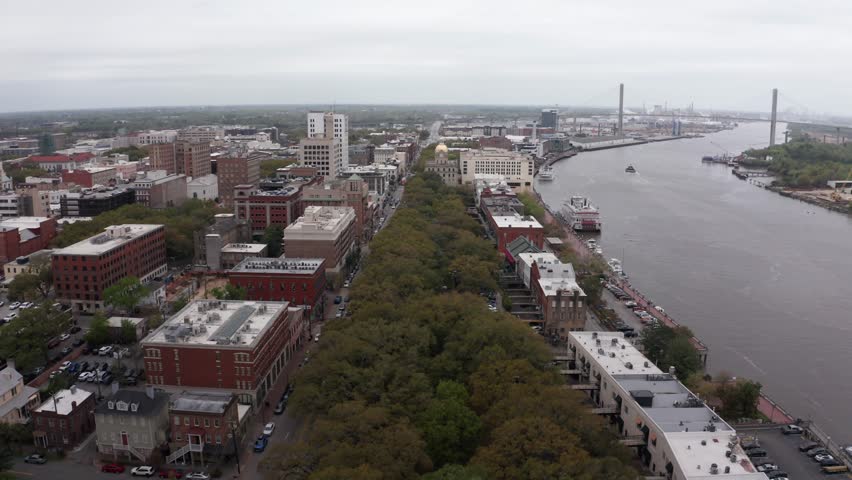 Low aerial shot flying over Emmet Park towards downtown Savannah, Georgia. 4K