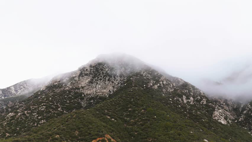 Circling Around Thick Fog Blowing Over Rocky Terrain, Surrounded by Trees. Foggy Afternoon in Angeles National Forest, California