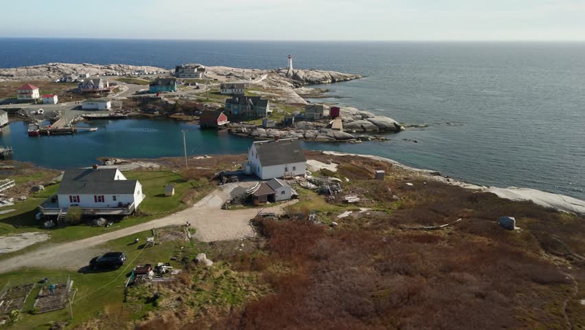 Cinematic drone shot of a fishing harbor and an ancient lighthouse at sunset in Peggy