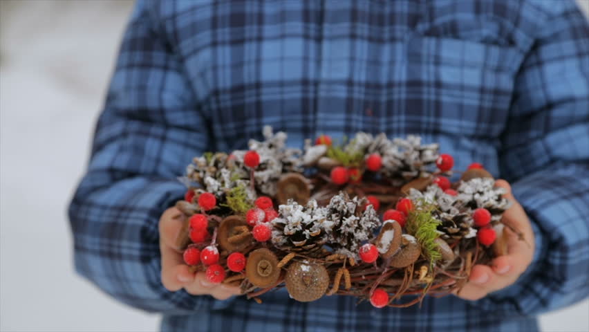 Christmas wreath of cones in the hands of a child
