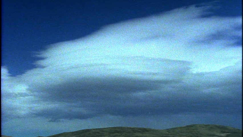 Timelapse of clouds moving over lush green hills