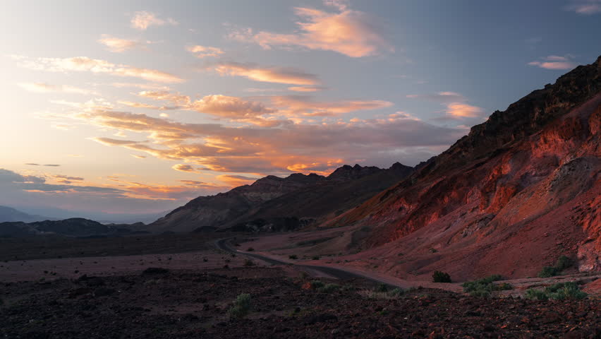 Scenic timelapse of mountains in Death Valley national park during sunset with dramatic orange clouds in the sky, Nevada, USA