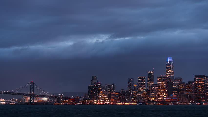 Timelapse of San Francisco city and Oakland Bay Bridge at night with clouds in the sky, California, USA