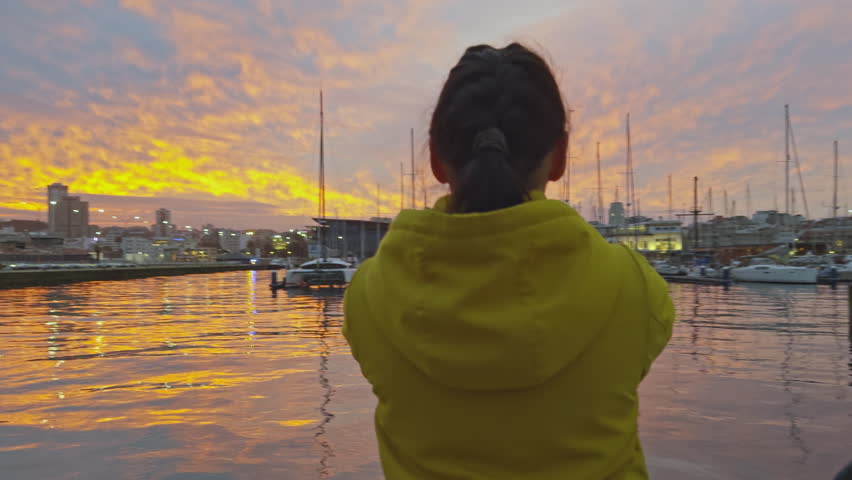 Tourist Capturing Sunset at Marina on Smartphone