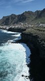 Experience the breathtaking coastal cliffs of Tenerife in this mesmerizing aerial video capturing the beauty of the sea meeting rugged cliffs