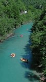 Aerial view of rafting boats on turquoise mountain river. Tara river canyon in Montenegro. Vertical video