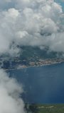 Aerial view on clouds over Kotor Bay, Montenegro. Flying in clouds over sea bay. Vertical video