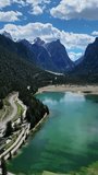 Aerial panorama view of Alpine lake Lago di Dobbiaco in Dolomites mountains, Cortina dAmpezzo, Italy. Lake Toblacher See, vertical video 4k