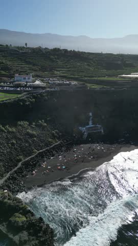 Enjoy a captivating aerial view of the black sand beach Playa El Bollullo in Tenerife, showcasing its natural beauty and coastal charm