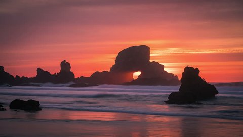 Sunset behind arch at Oregon coast, USA.