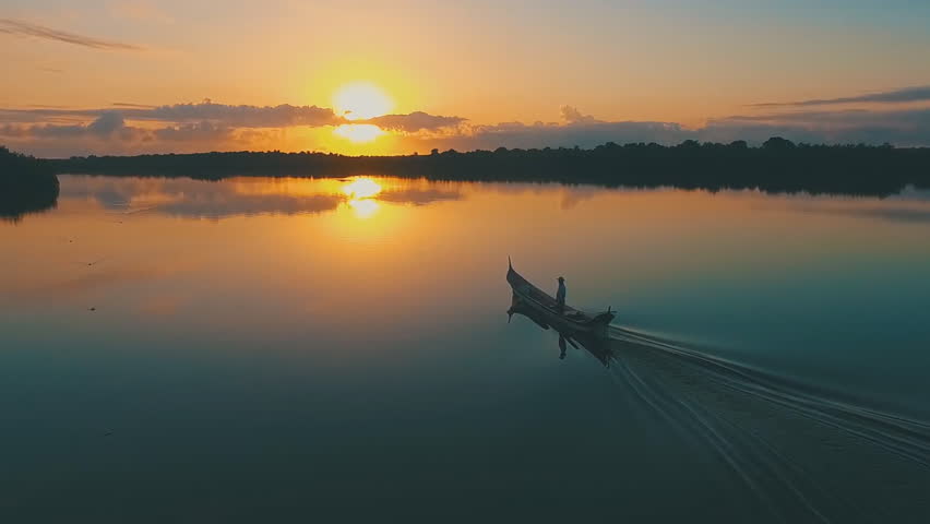 beautiful sunset on the lake, the fisherman swims by boat at sunset (Lake Taihu, China) aerial photography.