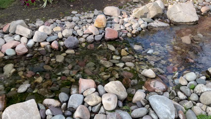 Relaxing flowing stream among flowers and ducks in a garden kept by the Commons at Sugarhouse within the historic and trendy Salt Lake suburb.