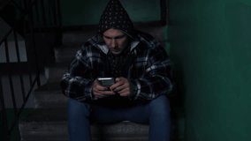 sad young man sitting in dark old condo using mobile phone. Loneliness sad man living alone thoughtful with stressed, family problems, Stress, violence, The concept of depression. - Powered by Shutterstock - Get 15% off with code: PIKWIZARD15