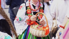 Łowicz Corpus Christi celebration. Young girls in traditional Masovian costumes throwing flower petals during religious procession. Slow motion video. Polish folklore