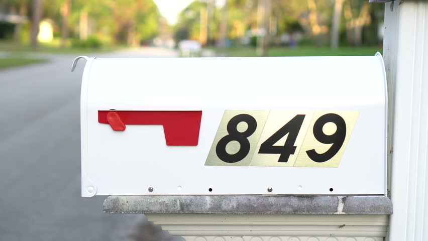 A male checks the mailbox for mail.  Close up of mailbox.