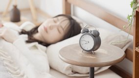 A woman who turns off her alarm and goes back to sleep - Powered by Shutterstock - Get 15% off with code: PIKWIZARD15