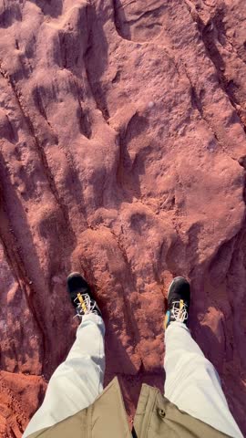 POV Point of view of young adult man sitting in front of Horseshoe Bend while rest and enjoying the landscape view at top of Grand Canyon National Park in Arizona, USA at sunset in winter time.
