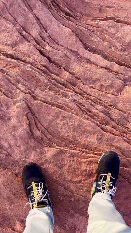 POV Point of view of young adult man sitting in front of Horseshoe Bend while rest and enjoying the landscape view at top of Grand Canyon National Park in Arizona, USA at sunset in winter time.