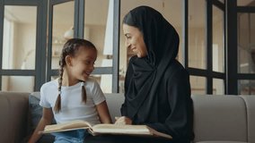 Mother and daughter studying together. Woman wearing hijab and abaya dress teaching and doing homework with her daughter - Powered by Shutterstock - Get 15% off with code: PIKWIZARD15
