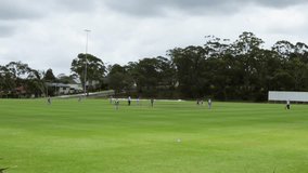 wide shot of cricket field with womens game playing on overcast day - Powered by Shutterstock - Get 15% off with code: PIKWIZARD15