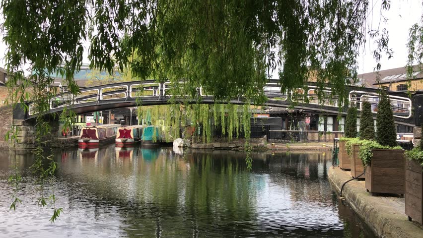 Bridge near Camden Lock on Regent Canal’s in London seen through weeping willows. Royalty-Free Stock Footage #3501174275