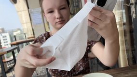 Woman hand using wet wipe and spray sanitizer to clean cell phone screen. People cleaning and disinfecting mobile telephone to kill germs. Girl hands holding smartphone. Over the shoulder view - Powered by Shutterstock - Get 15% off with code: PIKWIZARD15