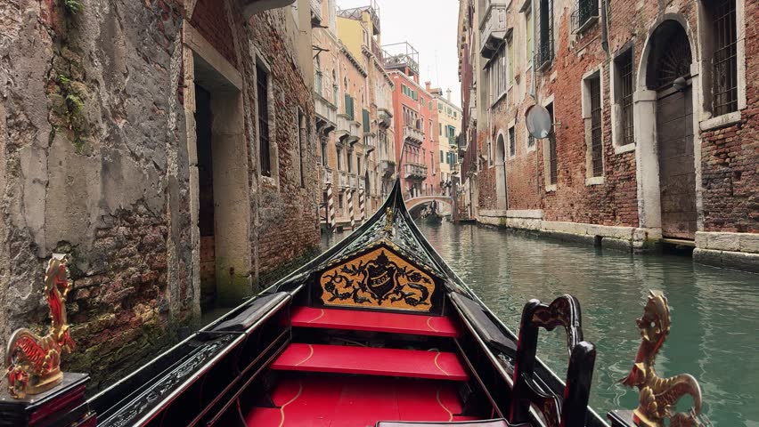 Italy, Venice, famous gondola ride through a typical narrow canal with small stone bridge inside the city. Relaxing moment with a first person view onboard camera. Royalty-Free Stock Footage #3501246643